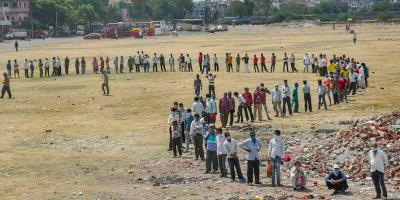 People stand in a queue to collect food from volunteers in Surat. Photo: PTI