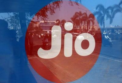 Commuters are reflected on an advertisement of Reliance Industries' Jio telecoms unit, at a bus stop in Mumbai, India, February 21, 2017. Photo: Reuters
