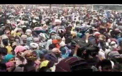 Workers throng the Ramlila ground in Ghaziabad, anxious to secure a seat on special trains that can take them back to eastern Uttar Pradesh and Bihar. Photo: Screengrab of video posted on Twitter by @Benarasiyaa
