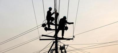 Technicians are silhouetted as they fix cables on a power transmission line in Karachi, Pakistan January 9, 2017. Photo: Reuters/Akhtar Soomro