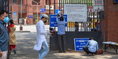 A worker hangs a notice on the main gate of LNJP Hospital during the COVID-19 lockdown in New Delhi. Photo: PTI