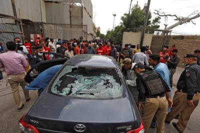 Police officers survey a damaged car at the site of an attack at the Pakistan Stock Exchange entrance in Karachi June 29, 2020. REUTERS/Akhtar Soomro
