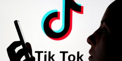 A person holds a smartphone as Tik Tok logo is displayed behind in this picture illustration taken November 7, 2019. Illustration: Reuters/Dado Ruvic/Files