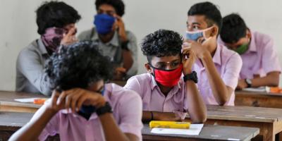 Students wearing face masks wait to sit vocational higher secondary education exams that had been postponed amid the pandemic, inside a school in Kochi, May 26, 2020. Photo: Reuters
