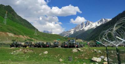Indian army soldiers walk past their parked trucks at a makeshift transit camp before heading to Ladakh, near Baltal, southeast of Srinagar, June 16, 2020. Photo: Reuters/Stringer