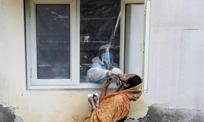 A health worker in personal protective equipment (PPE) collects a sample using a swab from a person at a local health centre to conduct tests for the coronavirus disease (COVID-19), amid the spread of the disease, in New Delhi, India October 7, 2020. REUTERS/Adnan Abidi