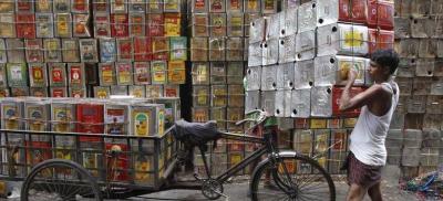 A man loads empty containers of edible oil onto a tricycle at a roadside in Kolkata, India, August 27, 2015. Photo: Reuters/Rupak De Chowdhuri