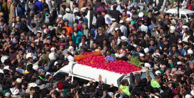 People gather near an ambulance carrying the body of Khadim Hussain Rizvi, leader of religious and political party Tehreek-e-Labaik Pakistan (TLP), during the funeral service as the outbreak of the coronavirus disease (COVID-19) continues, in Lahore, Pakistan November 21, 2020. Photo: Reuters/Mohsin Raza
