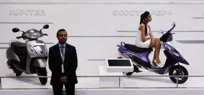 A model sits on a scooter at the TVS Motor company's pavilion during the Indian Auto Expo in Greater Noida, on the outskirts of New Delhi, February 6, 2014. Photo: Reuters/Adnan Abidi/File Photo