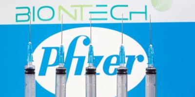 Syringes seen in front of BioNTech and Pfizer logos. Photo: Reuters/Dado Ruvic/File Photo.