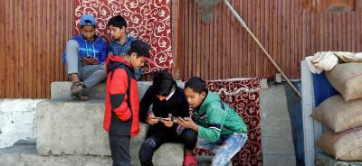 Children play games on their mobile phones in a neighbourhood in Srinagar October 10, 2019. Photo: Reuters/Danish Ismail