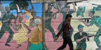 A man walks past a mural depicting fighting during the war in Colombo, Sri Lanka on April 27, 2011. Photo: Reuters/Andrew Caballero-Reynolds 