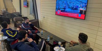 People watch Libya's parliament meet to vote on a unity government on a TV screen at a cafe in Misrata, Libya March 10, 2021. Photo: Reuters/Ayman Al-Sahili