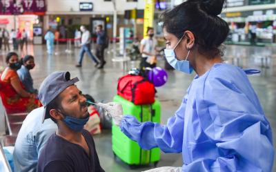 A health worker takes a swab sample of a outstation passenger for COVID-19 tests at the Chhatrapati Shivaji Maharaj Terminus, amid the ongoing surge in coronavirus cases, in Mumbai, Monday, April 12, 2021. Photo: PTI