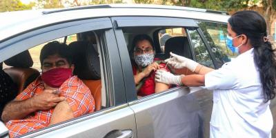 A medic inoculates beneficiaries with COVID-19 vaccine inside their cars during the second wave of coronavirus pandemic, in Bhopal, Saturday, May 1, 2021. Photo: PTI