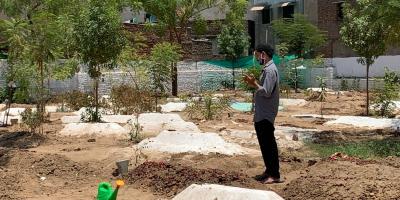 Junaid Shaikh praying at his mother’s two-day-old grave at the Namara kabristan specially created for COVID-19 victims last year. The graveyard is completely full and will stop accepting bodies in 10 days. Photo: Jumana Shah 
