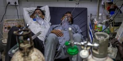 Patients suffering from COVID-19 share a bed as they receive treatment at the casualty ward in Lok Nayak Hospital in New Delhi, April 15, 2021. Photo: Reuters/Danish Siddiqui/