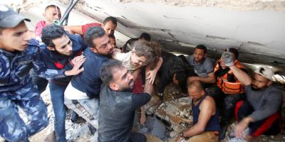 Rescuers carry Suzy Eshkuntana, 6, as they pull her from the rubble of a building at the site of Israeli air strikes, in Gaza City May 16, 2021. REUTERS/Mohammed Salem