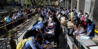 Representative image. Job seekers fill up forms as others line up for registration during a job fair in Chinchwad, India February 7, 2019. Photo: Reuters/Danish Siddiqui/File Photo
