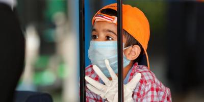 A child wearing a protection mask and gloves is seen at Indira Gandhi International (IGI) airport, after the government allowed domestic flight services to resume, during an extended nationwide lockdown to slow the spread of the coronavirus disease (COVID-19), in New Delhi, India, May 25, 2020. Photo: Reuters/Adnan Abidi