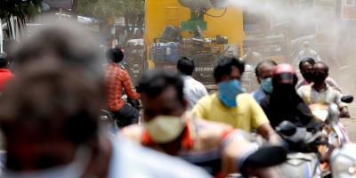 People wearing face masks ride motorcycles as a municipal vehicle decontaminates a road during a 21-day nationwide lockdown to slow the spreading of coronavirus disease (COVID-19), in Chennai, India, April 9, 2020. Photo: Reuters/P. Ravikumar