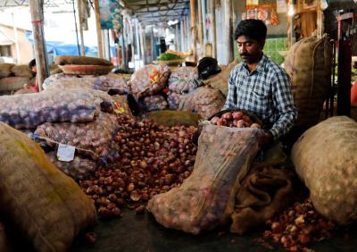 A vendor puts onions in a sack after sorting them at a vegetable market in Mumbai, India, June 12, 2018. Photo: Reuters/Danish Siddiqui