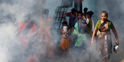 Women and children cover their faces from a fumigation drive, during a nationwide lockdown in India to slow the spread of COVID-19, in Dharavi, one of Asia's largest slums, during the coronavirus disease outbreak, in Mumbai, India, April 9, 2020. Photo: Reuters/Francis Mascarenhas