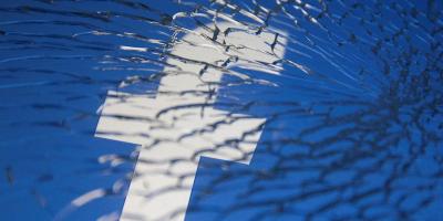 Facebook logo displayed through broken glass in this illustration. Photo: Reuters/Dado Ruvic