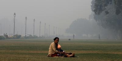 A mother and child sit amidst the smog at India Gate. Photo: Reuters