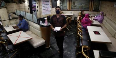A waiter walks past tables that have been blocked to maintain social distancing at restaurant amidst the spread of COVID-19 in Mumbai, October 8, 2020. Photo: Reuters/Francis Mascarenhas/File photo