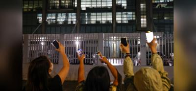 Supporters light torch lights from their phones outside the headquarters of the Apple Daily newspaper, and its publisher Next Digital, after announcement that the newspaper is folding its operations earlier, in Hong Kong, China June 23, 2021. Photo: Reuters/Tyrone Siu.