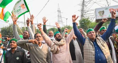 Farmers wave the national flags and raise slogans as they celebrate after Samyukta Kisan Morcha announced to call off the farmers agitation, at Ghazipur border in New Delhi, Thursday, December 9, 2021. Photo: PTI