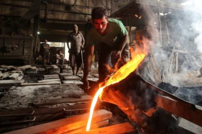 FILE PHOTO: A worker pours molten iron from a ladle to make automobile spare parts inside an iron casting factory in Ahmedabad, India, January 31, 2019. Photo: Reuters/Amit Dave