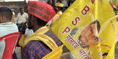A man sports an 'Akhilesh Yadav' hat and carries an SBSP flag. Photo: Radhika Bordia