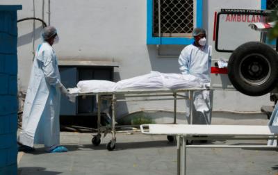 Representative image. Mortuary workers load the body of a person, who died from the coronavirus disease (COVID-19), to an ambulance for cremation in New Delhi in 2021. Photo: Reuters