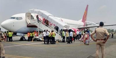 Passengers come out of the Delhi-bound SpiceJet airplane following its emergency landing after it caught fire mid-air, at Jai Prakash Narayan airport, in Patna, June 19, 2022. Photo: PTI