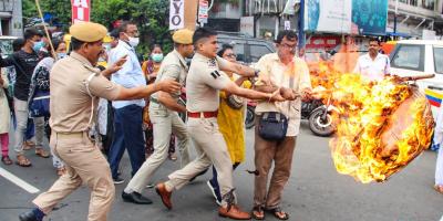Police personnel try to snatch a burning effigy from a protester during a protest against the Agnipath scheme, in Kolkata, June 18, 2022. Photo: PTI