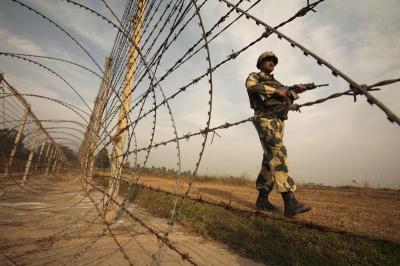 An Indian Border Security Force (BSF) soldier patrols near the fenced border with Pakistan in Suchetgarh, southwest of Jammu. Photo: Reuters/Mukesh Gupta