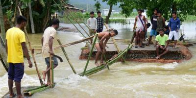 Goalpara: Villagers make a temporary bamboo bridge after a portion of a road was washed away by the flood water at a village in Goalpara district of Assam state, Saturday, June 18 2022. Photo: PTI