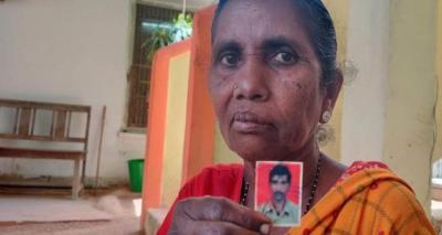 Jalli Lakshmi, holding a photo of her son. Photo: TNM