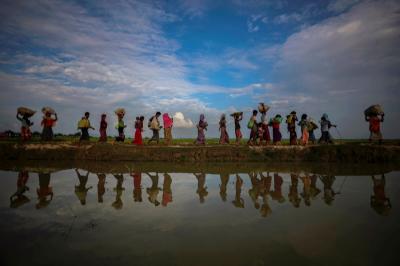 File photo: Rohingya refugees are reflected in rain water along an embankment next to paddy fields after fleeing from Myanmar into Palang Khali, near Cox's Bazar, Bangladesh November 2, 2017. Credit: Reuters/Hannah McKay/File Photo