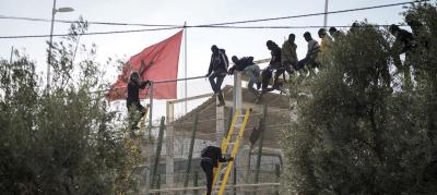 African migrants sit on top of a border fence during an attempt to cross from Morocco into Spain's north African enclave of Melilla, November 21, 2015. Photo: Reuters/Jesus Blasco de Avellaneda/File Photo