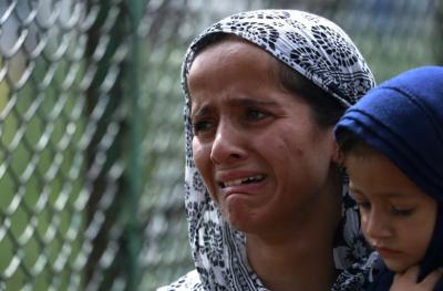 A Kashmiri woman cries as she carries a baby during clashes between protestors and security forces. Photo: Reuters/Danish Ismail 