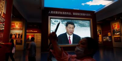 FILE PHOTO: A visitor takes pictures in front of a screen displaying an image of Chinese President Xi Jinping, at the Museum of the Communist Party of China in Beijing, China September 3, 2022. Photo: Reuters/Florence Lo