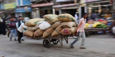 Workers transport sacks that are loaded on a cart at a wholesale market in the old quarters of Delhi. Photo: Reuters/Anushree Fadnavis/Files