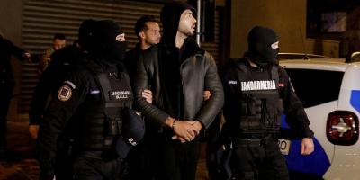 Andrew Tate and Tristan Tate are escorted by police officers outside the headquarters of the Directorate for Investigating Organized Crime and Terrorism in Bucharest (DIICOT) after being detained for 24 hours, in Bucharest, Romania, December 29, 2022. Inquam Photos/Octav Ganea via Reuters