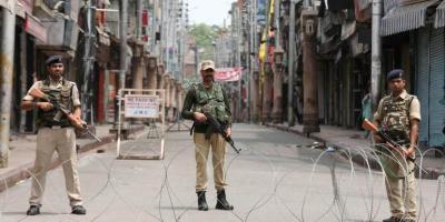 A jawan stands guard along a deserted street in Kashmir. Photo: Reuters/Mukesh Gupta