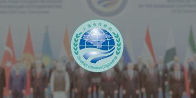 The SCO logo. In the background are SCO leaders at the 2022 Samarkand meet. Photos: File.