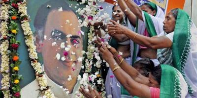 Followers shower a portrait of Rajiv Gandhi with flowers. Credit: PTI