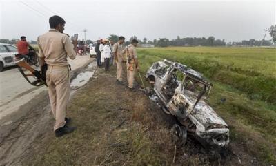 Police personnel look at the overturned SUV which was destroyed in violence during farmers' protest, in Tikonia area of Lakhimpur Kheri district on October 4, 2021. Photo: PTI/File